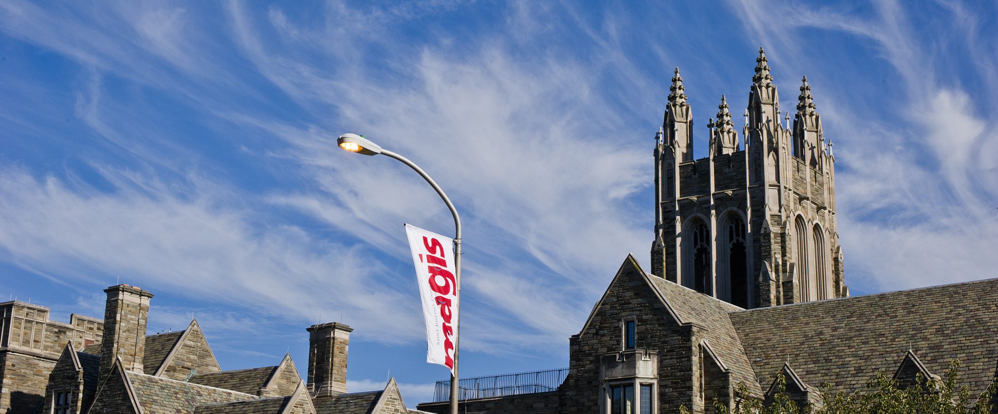 Barbelin Tower and a flag that reads MAGIS at Saint Joseph's University
