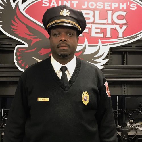 Stacey McLean is standing in front of a "Saint Joseph's Public Safety" sign in his uniform.